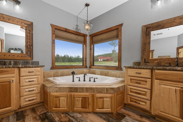 bathroom with a bathing tub, vanity, and hardwood / wood-style flooring