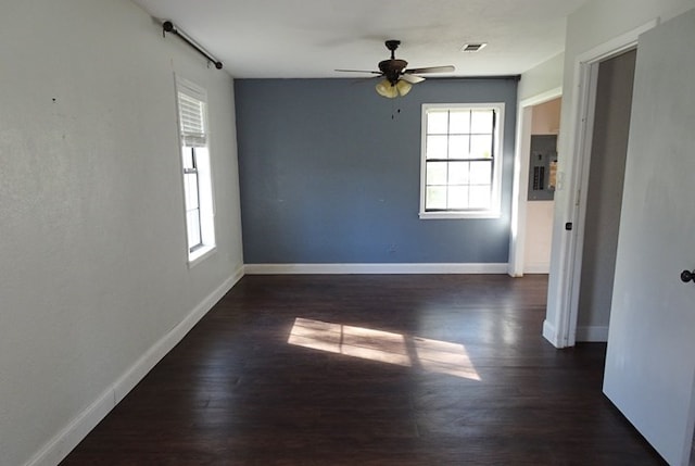 spare room featuring dark hardwood / wood-style floors, ceiling fan, and electric panel