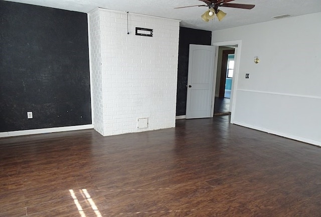 spare room with a textured ceiling, ceiling fan, and dark wood-type flooring