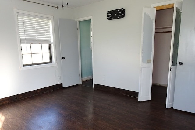 unfurnished bedroom with dark wood-type flooring and a closet