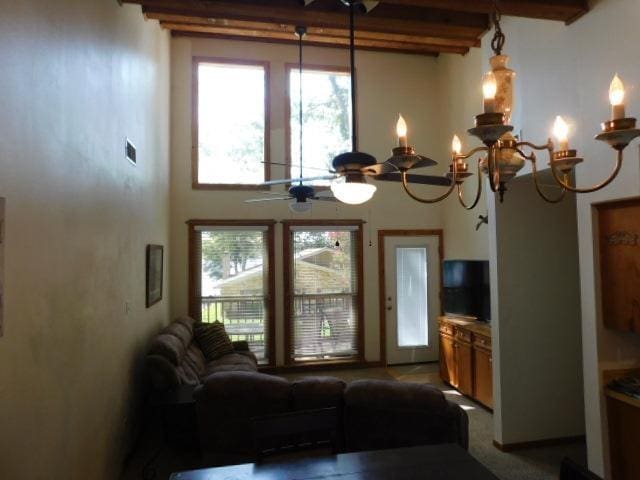 living room featuring beam ceiling and ceiling fan with notable chandelier