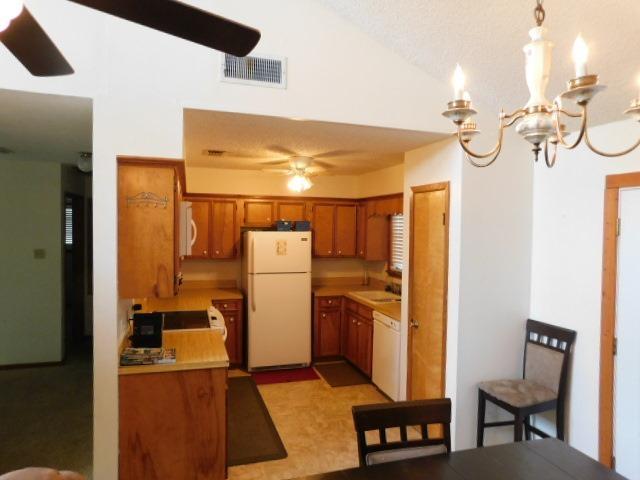 kitchen with ceiling fan with notable chandelier, decorative light fixtures, and white appliances