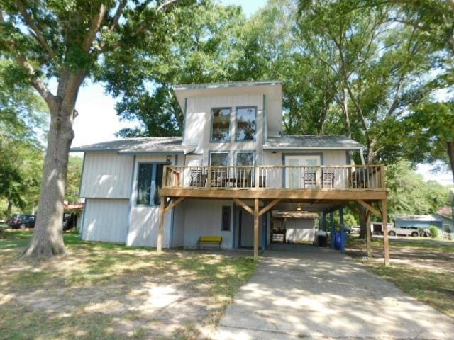 rear view of property with a wooden deck and a carport