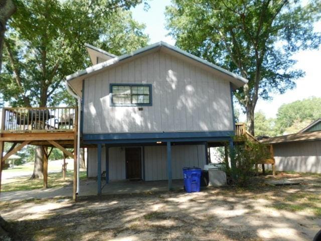 view of property exterior with a patio area and a wooden deck