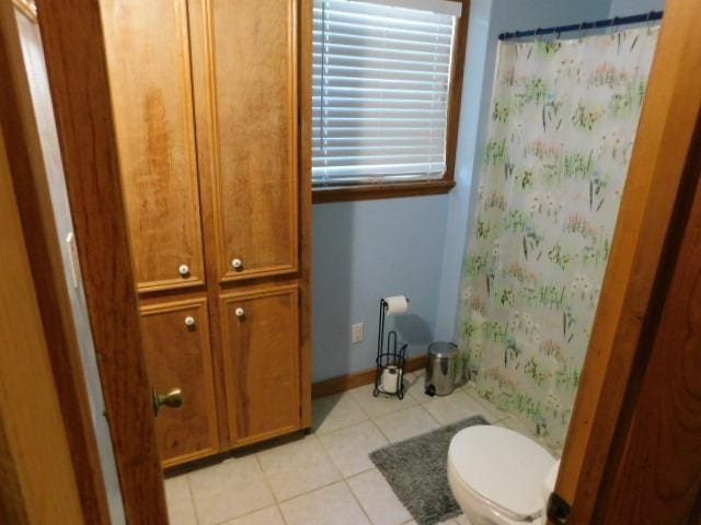 bathroom with toilet, tile patterned flooring, and a shower with shower curtain