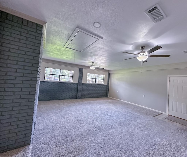 213 Crosstimbers St, Lufkin, TX 75904 - spare room featuring attic access, a ceiling fan, carpet, healthy amount of natural light, and brick wall
