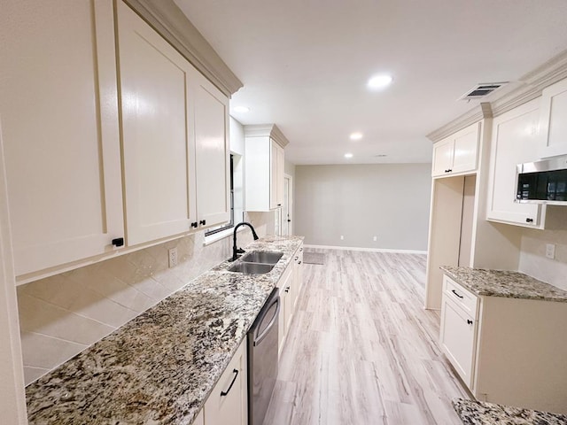 213 Crosstimbers St, Lufkin, TX 75904 - kitchen with a sink, appliances with stainless steel finishes, light stone countertops, recessed lighting, and light wood-style flooring