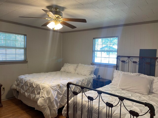 bedroom with ceiling fan, crown molding, and hardwood / wood-style flooring