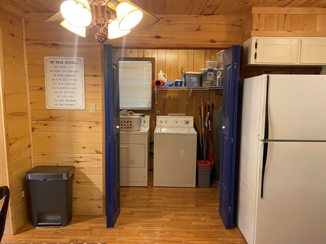 laundry room featuring separate washer and dryer, a notable chandelier, wood walls, light hardwood / wood-style floors, and wood ceiling