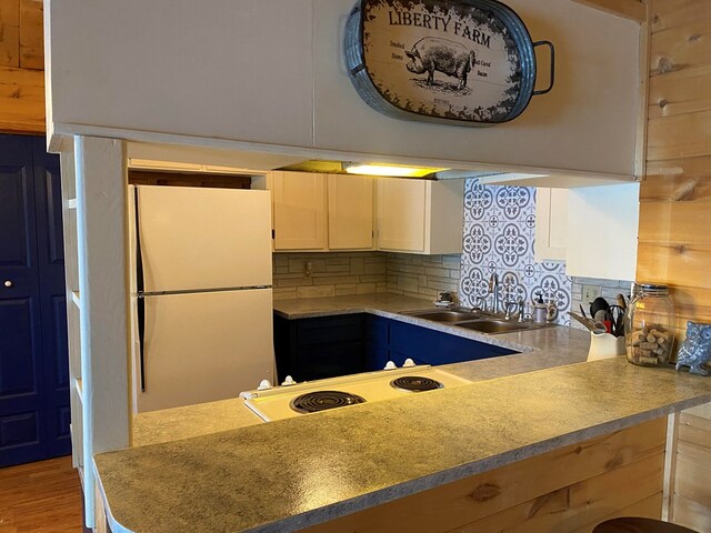 kitchen with sink, light hardwood / wood-style flooring, white appliances, decorative backsplash, and white cabinets