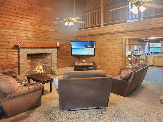 carpeted living room with a towering ceiling, a fireplace, and a ceiling fan