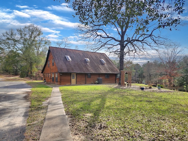 view of home's exterior featuring a shingled roof, a lawn, and log exterior