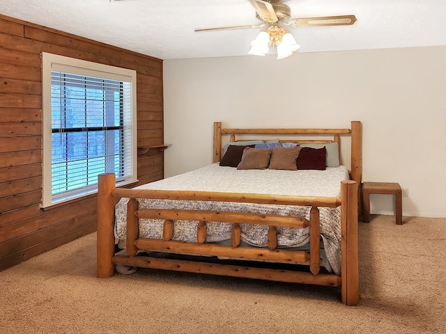 bedroom featuring ceiling fan, carpet floors, and wood walls