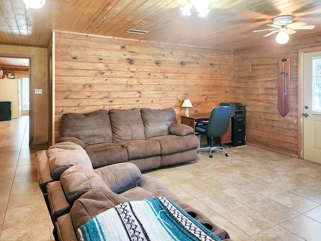 living area featuring wooden ceiling, light tile patterned floors, wood walls, and ceiling fan