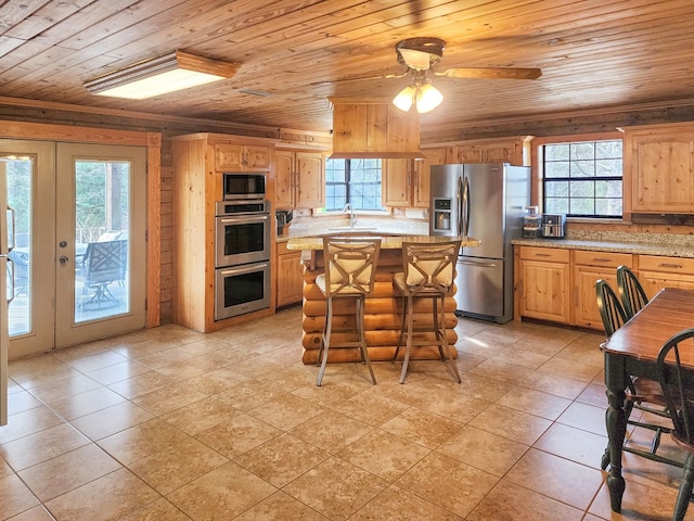 kitchen featuring appliances with stainless steel finishes, wooden ceiling, a sink, and a wealth of natural light