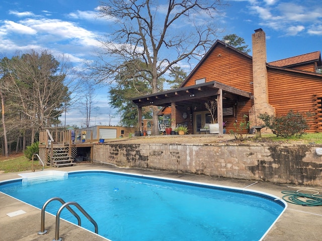 pool with a wooden deck and stairs