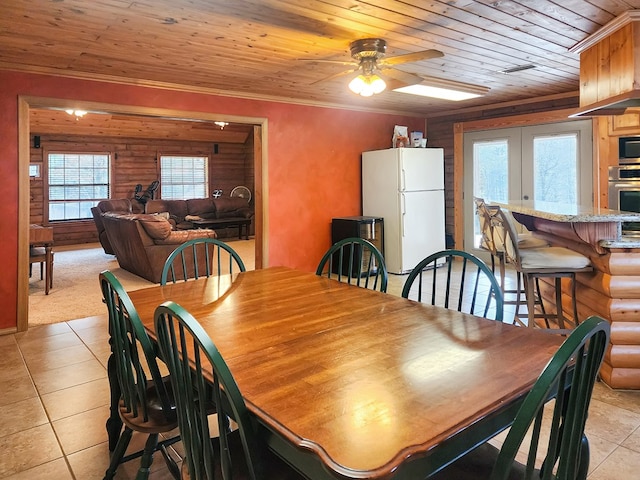 dining room with french doors, log walls, light tile patterned floors, ornamental molding, and wooden ceiling