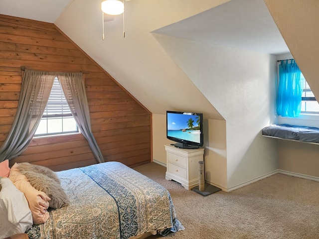 bedroom with carpet floors, wood walls, baseboards, and lofted ceiling