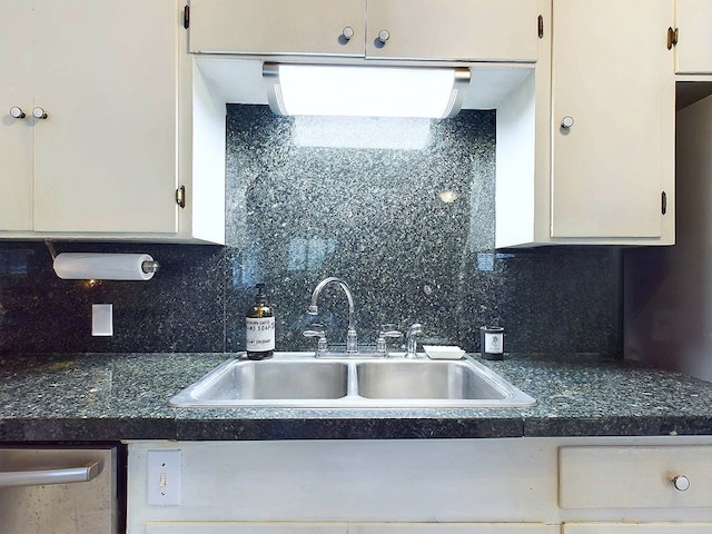 kitchen with tasteful backsplash, white cabinetry, and sink