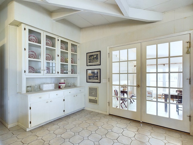 interior space featuring beamed ceiling, french doors, and heating unit