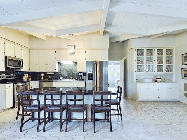 kitchen featuring sink, stainless steel appliances, lofted ceiling with beams, white cabinets, and decorative backsplash