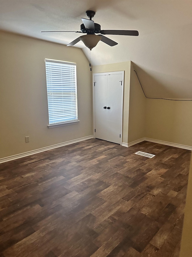 additional living space featuring dark hardwood / wood-style floors, ceiling fan, and vaulted ceiling