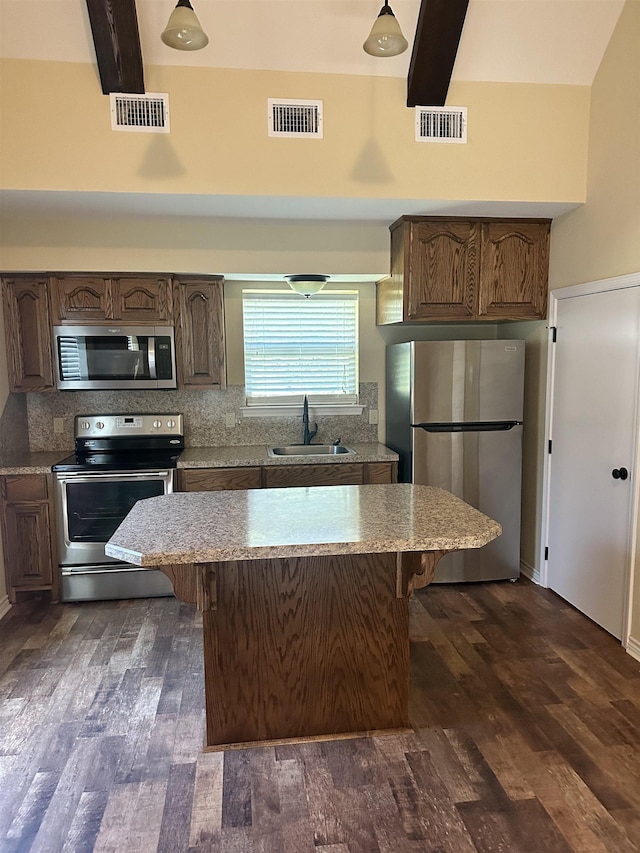 kitchen featuring sink, dark hardwood / wood-style floors, decorative backsplash, appliances with stainless steel finishes, and beam ceiling