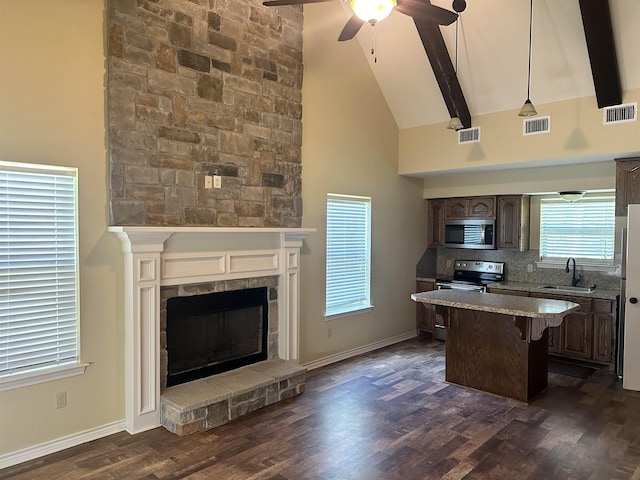 kitchen with beam ceiling, sink, high vaulted ceiling, and stainless steel appliances