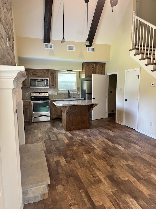 kitchen with beamed ceiling, stainless steel appliances, high vaulted ceiling, and dark wood-type flooring