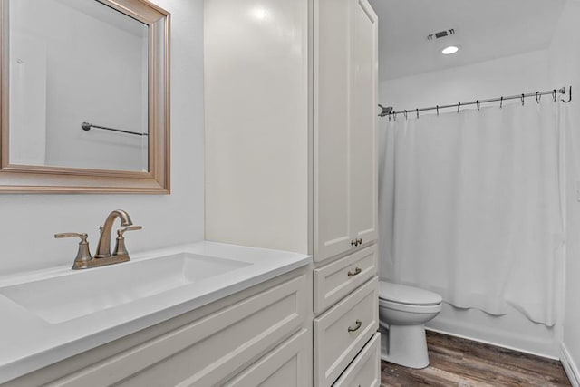 full bathroom featuring toilet, hardwood / wood-style floors, vanity, and shower / tub combo with curtain