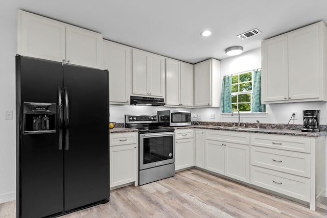 kitchen with white cabinetry, sink, extractor fan, appliances with stainless steel finishes, and light wood-type flooring