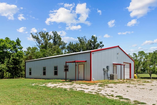 view of outdoor structure featuring a lawn and central AC unit