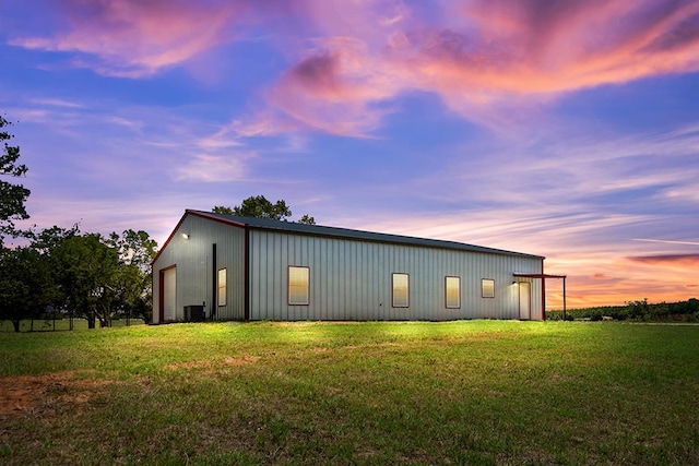 exterior space with a yard, central AC unit, and an outdoor structure