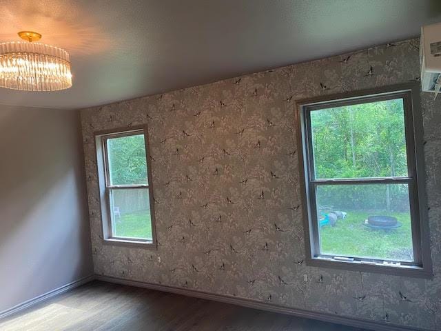 empty room with plenty of natural light and wood-type flooring