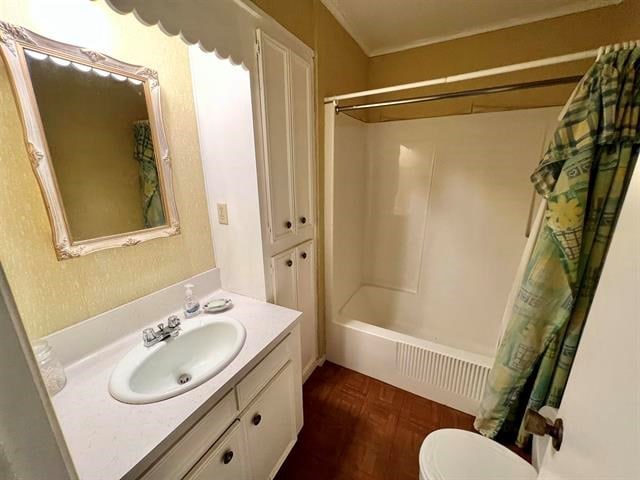 full bathroom with vanity, toilet, shower / bathtub combination with curtain, and parquet floors