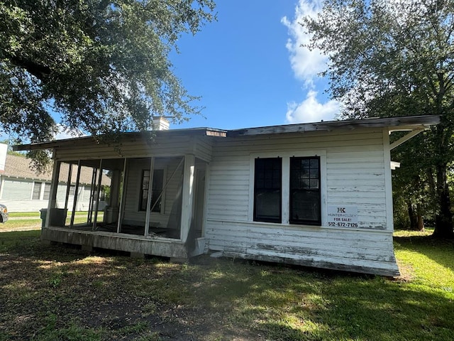 906 6th St, Orange, TX 77360 - back of house with a chimney, a yard, and a sunroom