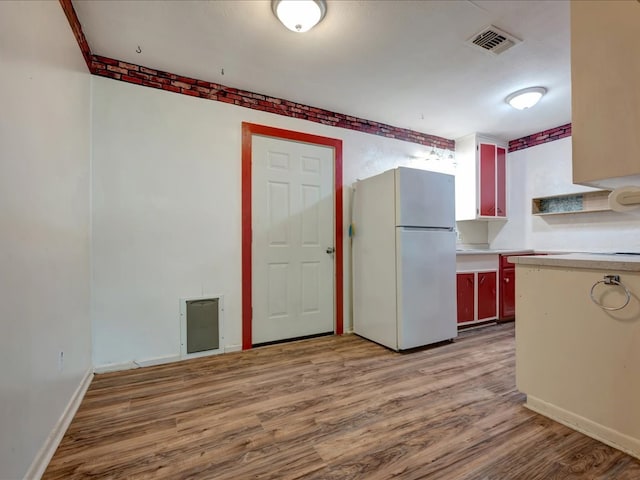 1313 Glass Ave, Diboll, TX 75941 - kitchen with freestanding refrigerator, wood finished floors, and light countertops