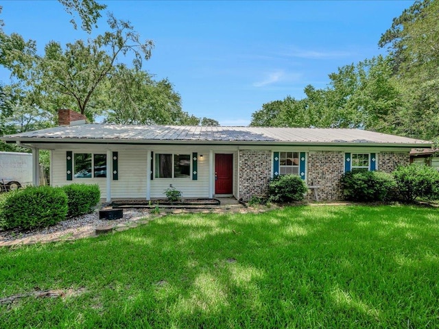 1313 Glass Ave, Diboll, TX 75941 - ranch-style home featuring a chimney, a front lawn, and a metal roof