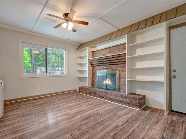 1313 Glass Ave, Diboll, TX 75941 - unfurnished living room with wood finished floors, a ceiling fan, a fireplace, built in shelves, and ornamental molding