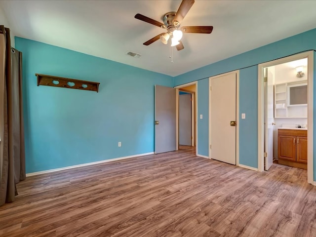 1313 Glass Ave, Diboll, TX 75941 - unfurnished bedroom with wood finished floors, ceiling fan, and ensuite bath