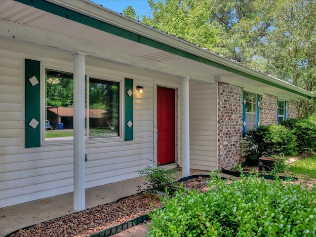 1313 Glass Ave, Diboll, TX 75941 - doorway to property featuring brick siding and a porch
