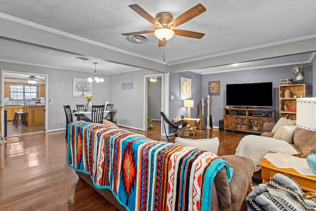 living room featuring hardwood / wood-style floors, ceiling fan with notable chandelier, a textured ceiling, and ornamental molding