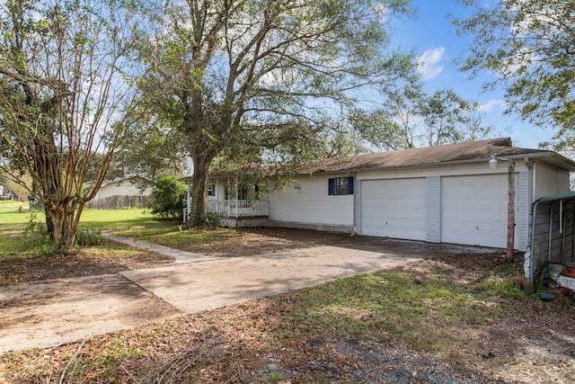 ranch-style home with a front yard, a porch, and a garage