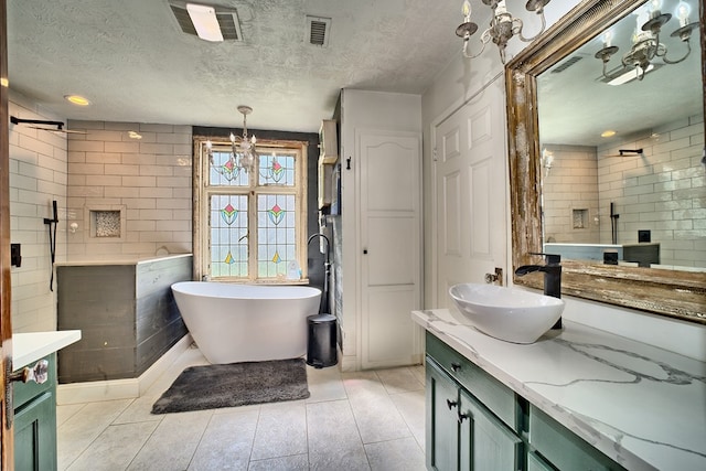 bathroom with independent shower and bath, vanity, a chandelier, and a textured ceiling