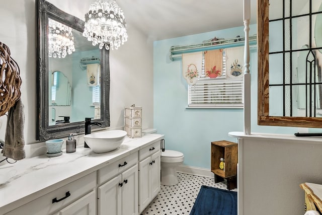 bathroom featuring vanity, toilet, and a chandelier