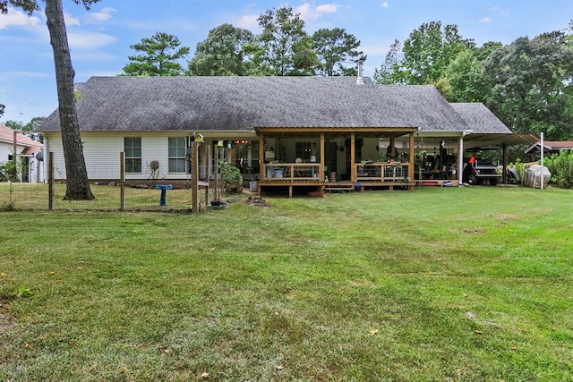 back of property featuring a carport and a lawn