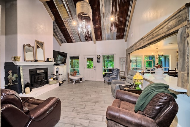 living room with light hardwood / wood-style floors, high vaulted ceiling, and a notable chandelier