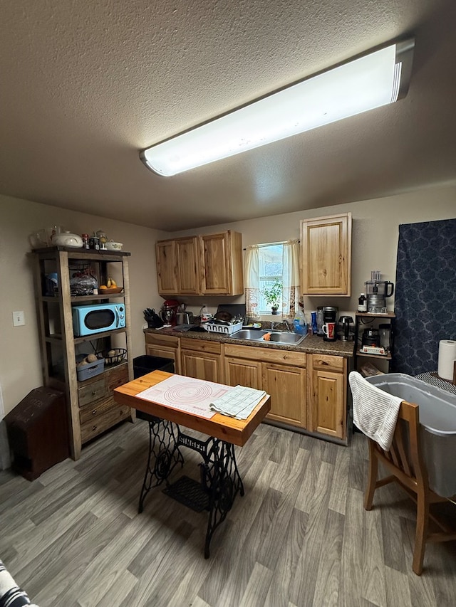 kitchen with sink, hardwood / wood-style flooring, and a textured ceiling