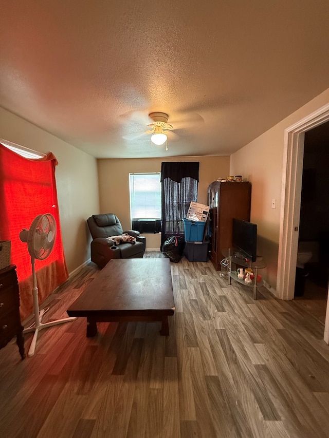 sitting room featuring a textured ceiling, hardwood / wood-style floors, and ceiling fan