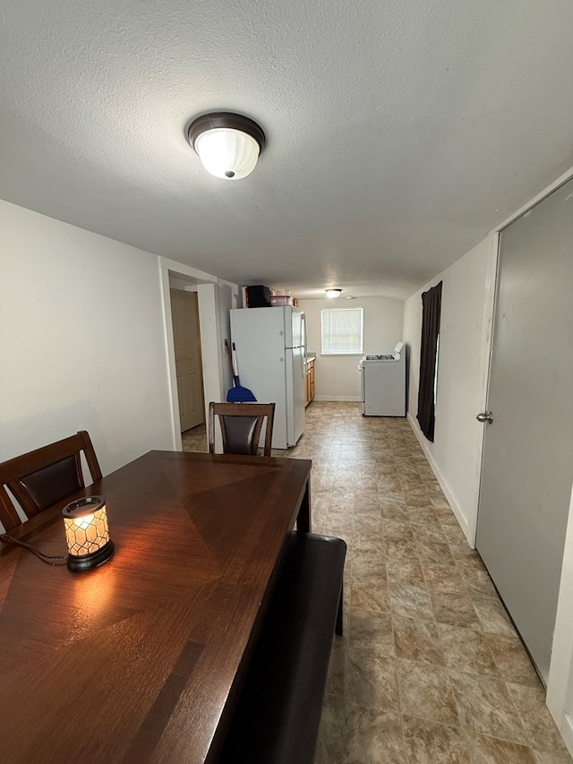 dining area with washer / clothes dryer and a textured ceiling